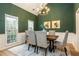 Elegant dining room features a dark green accent wall, chandelier, and natural light at 2918 Arbor Creek Ln, Atlanta, GA 30340