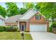 Charming brick home featuring manicured lawn, two-car garage, and lush landscaping at 2918 Arbor Creek Ln, Atlanta, GA 30340