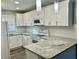 Bright kitchen featuring white cabinets, granite countertops, modern appliances, and a stylish backsplash at 2961 Stone Mountain St, Lithonia, GA 30058