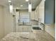 Well-lit kitchen featuring white cabinets, granite countertops, a modern faucet, and sleek pendant lighting at 2961 Stone Mountain St, Lithonia, GA 30058