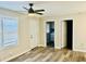 Spacious living room featuring wood-look flooring, a modern ceiling fan, and a view into the laundry room at 2961 Stone Mountain St, Lithonia, GA 30058