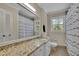 Clean bathroom featuring a granite countertop, white cabinets, and large mirror at 3563 Castleridge Dr, Tucker, GA 30084