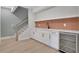 Basement wet bar featuring white cabinetry, copper backsplash, and beverage refrigerator at 159 Sunshower Rdg, Canton, GA 30114