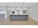 Spacious kitchen boasts a large gray island, white cabinets, stainless steel appliances, and pendant lighting at 159 Sunshower Rdg, Canton, GA 30114