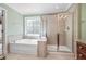 Bathroom featuring a soaking tub, shower with glass doors, and a decorative window for added elegance at 2827 Overlook Ne Trce, Atlanta, GA 30324