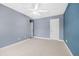 Bedroom featuring neutral carpet, calming blue walls, a ceiling fan, and natural light from a nearby window at 2827 Overlook Ne Trce, Atlanta, GA 30324