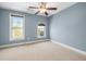 Bedroom featuring a ceiling fan, neutral carpet, calming blue walls, and natural light from two large windows at 2827 Overlook Ne Trce, Atlanta, GA 30324