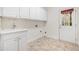 Bright laundry room with white cabinets, tile flooring, and exterior door at 2827 Overlook Ne Trce, Atlanta, GA 30324