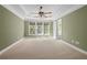 This carpeted main bedroom features a tray ceiling, ceiling fan, and ensuite bath at 2827 Overlook Ne Trce, Atlanta, GA 30324