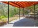 Covered outdoor patio with exposed beams, metal support beams, and lush green backyard at 2827 Overlook Ne Trce, Atlanta, GA 30324
