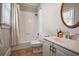Well-lit bathroom featuring a shower over tub, white cabinetry, and a round mirror at 4030 Palisades Main Nw, Kennesaw, GA 30144