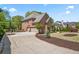 Brick home features a multi-car garage, a lush lawn, and a concrete driveway at 4030 Palisades Main Nw, Kennesaw, GA 30144
