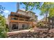 Two-story house featuring large deck, landscaped backyard, and a stone paver patio at 4030 Palisades Main Nw, Kennesaw, GA 30144