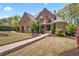 A beautiful brick home with a manicured lawn and lush landscaping creates a welcoming atmosphere at 4030 Palisades Main Nw, Kennesaw, GA 30144