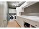 Well-equipped laundry room with washer, dryer, cabinets, and a utility sink at 4030 Palisades Main Nw, Kennesaw, GA 30144