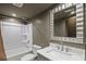Bathroom features a shower-tub combo, a gray vanity, and a decorative mirror at 4232 Rue Saint Dominique, Stone Mountain, GA 30083