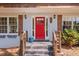 Charming home exterior featuring a red door, brick facade and wood-accented railings and shutters at 4232 Rue Saint Dominique, Stone Mountain, GA 30083