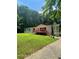 Inviting single-story home with a spacious front yard, front deck, and mature trees at 6650 George Ct, Cumming, GA 30041