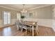 Formal dining room features hardwood floors, elegant chandelier, and wainscoting at 7050 Redcliff Ct, Suwanee, GA 30024