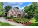 Charming brick home featuring a manicured front lawn, lush landscaping, and a welcoming entrance at 7050 Redcliff Ct, Suwanee, GA 30024