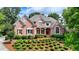 Beautiful brick home with meticulously landscaped front yard and traditional architectural details at 7050 Redcliff Ct, Suwanee, GA 30024