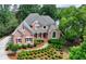 Stately brick home features a meticulously landscaped front yard and charming architectural details at 7050 Redcliff Ct, Suwanee, GA 30024