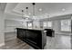 An open kitchen area boasts dark cabinets, stone countertops, and plenty of room to entertain at 7050 Redcliff Ct, Suwanee, GA 30024