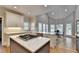 Open-concept kitchen boasts an eat-in area, a granite island, and hardwood floors at 7050 Redcliff Ct, Suwanee, GA 30024