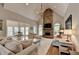 Open living room features a stone fireplace, hardwood floors, and lots of natural light at 7050 Redcliff Ct, Suwanee, GA 30024