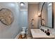 Stylish powder room with unique wall decor, marble countertop, and updated fixtures at 7050 Redcliff Ct, Suwanee, GA 30024