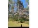 Backyard view featuring a dogwood tree in bloom, set amidst mature trees and a fenced perimeter at 1132 Owen Cir, Sugar Hill, GA 30518