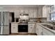 Modern kitchen with stainless steel appliances, granite countertops, and white cabinets at 1132 Owen Cir, Sugar Hill, GA 30518