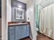 Charming bathroom with blue vanity and sink, complemented by a decorative mirror and tiled shower at 1527 Keeter Rd, Canton, GA 30114