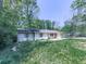 An modest single-story house has a well-manicured lawn surrounded by lush trees at 1527 Keeter Rd, Canton, GA 30114