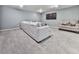 Finished basement living room with large gray sectional couch, plush carpeting, and wall-mounted TV at 1017 Fairway Valley Dr, Woodstock, GA 30189
