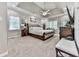 Spacious bedroom featuring a tray ceiling, carpeted floors, tufted headboard, and abundant natural light at 1017 Fairway Valley Dr, Woodstock, GA 30189