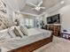 Bright bedroom featuring a ceiling fan, mounted TV, and a large tufted headboard at 1017 Fairway Valley Dr, Woodstock, GA 30189