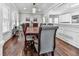 Formal dining room featuring hardwood floors, large windows, and a wooden table with seating for eight at 1017 Fairway Valley Dr, Woodstock, GA 30189