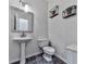 Powder room with modern fixtures, pedestal sink, decorative shelves, and a tiled floor at 1017 Fairway Valley Dr, Woodstock, GA 30189