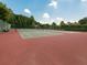 Community tennis courts with red surface, surrounded by green trees and bushes at 1017 Fairway Valley Dr, Woodstock, GA 30189