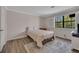 Cozy bedroom with a queen bed, wood floors, and a large window with a peaceful view at 110 Barrington Hills Dr # 110, Atlanta, GA 30350