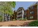 Multi-story brick apartment building nestled among mature trees on a sunny day at 110 Barrington Hills Dr # 110, Atlanta, GA 30350