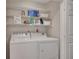 Practical laundry room with a washer, dryer, and shelving for organized storage at 110 Barrington Hills Dr # 110, Atlanta, GA 30350