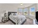 Inviting bedroom featuring carpet flooring, a large bed, three windows, and ample natural light at 1304 Slate Bend Dr, Dacula, GA 30019