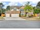 Two-story brick home featuring a three car garage and a beautifully landscaped front yard at 1304 Slate Bend Dr, Dacula, GA 30019