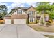 Two-story brick home featuring a three car garage and a beautifully landscaped front yard at 1304 Slate Bend Dr, Dacula, GA 30019