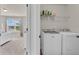 Modern laundry room with newer washer and dryer, shelving, and ample space at 1304 Slate Bend Dr, Dacula, GA 30019