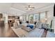 Bright living room features a large sectional sofa, tray ceiling, and hardwood floors at 1304 Slate Bend Dr, Dacula, GA 30019