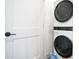 Modern, front-load washer and dryer are stacked in this well-lit laundry room at 200 Chestnut Cir, Atlanta, GA 30342