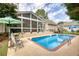 Backyard showcases a pool, surrounded by greenery, with patio furniture and a screened-in porch at 3818 Bay Forest Way, Loganville, GA 30052